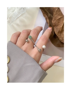 Detail of S925 silver open rings with green aventurine and white pearl on wrinkled band