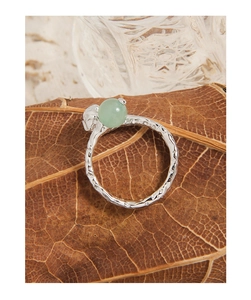 Detail of S925 silver ring with green aventurine stone and skull on a dry leaf