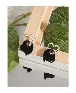 Close-up of S925 silver black heart earrings displayed on a mirrored wooden stand