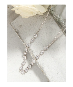 Détail macro du collier en argent S925 avec zircons brillants sur support pierre