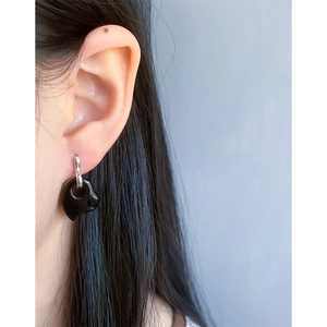 Minimalist S925 sterling silver hoop earrings with black heart pendant on a model