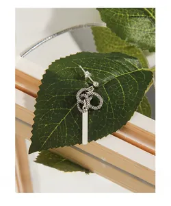 Close-up of S925 sterling silver earring featuring vintage snake knot and vertical metal bar