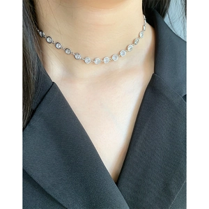 Collier minimaliste en argent S925 avec zircons pour femme porté sur un costume noir chic