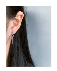 Detail of silver S925 snake texture hoop earring on ear with minimalist geometric charm