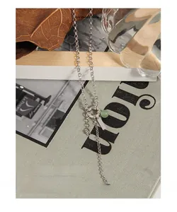 Detail of silver S925 long chain with green aventurine bead and geometric pendant