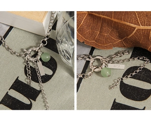 Detailed macro of S925 sterling silver chain with green aventurine bead and metal tag