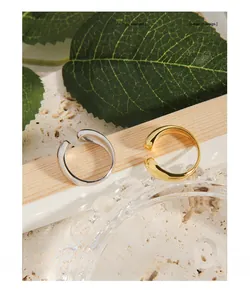Detailansicht minimalistischer offener Ringe in Gold und Silber mit glatter Oberfläche