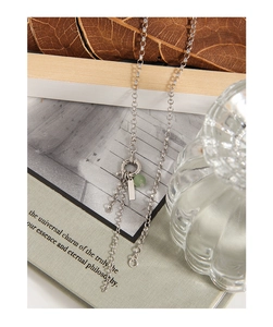Macro detail of S925 silver necklace with green aventurine bead and minimalist pendant