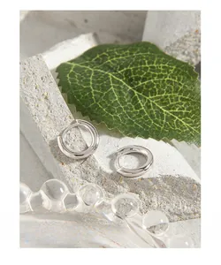Gros plan de créoles minimalistes en argent fin S925 avec finition polie brillante
