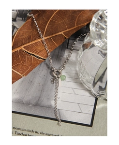 Detailed view of silver S925 necklace featuring green aventurine bead and metal tag pendant
