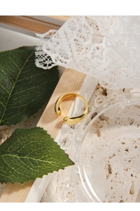 Minimalistischer goldener Ohrclip oder offener Ring mit polierter Kurve auf Stein