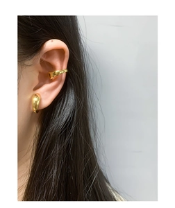 Nahaufnahme von minimalistischem Gold-Ear-Cuff-Set mit polierter Spiegeloberfläche am Ohr