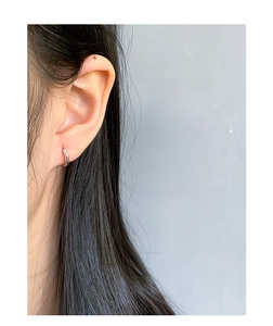 Gros plan d'une boucle d'oreille créole minimaliste en argent S925 sur un mannequin