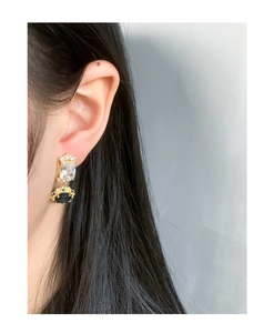 Close-up of vintage style drop earrings with blue gemstones and zircons on model