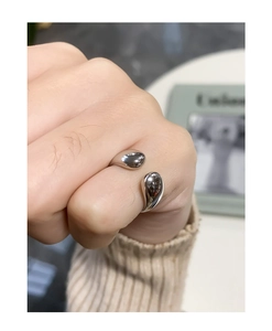 Nahaufnahme des polierten silbernen Tropfenrings mit modernem asymmetrischem Design
