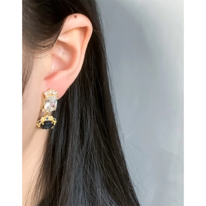 Vintage gold drop earrings with blue zircon stones worn by a model for a refined luxury look
