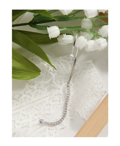Macro detail of S925 sterling silver ear cuff featuring sparkling cubic zirconia tassels
