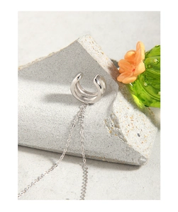 Close-up of S925 silver ear cuff with multilayer C-shape and long minimalist chain tassel