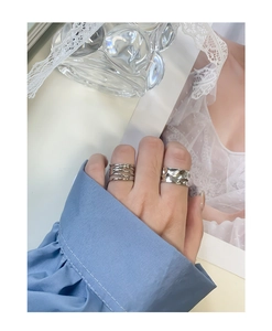 Detailed view of layered geometric silver rings worn with minimalist fashion styling
