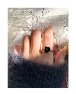 Detailed view of S925 silver ring featuring a black heart charm on model's hand