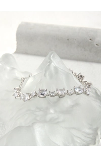 Detailed view of silver S925 bracelet featuring multi-shape cubic zirconia in prong setting