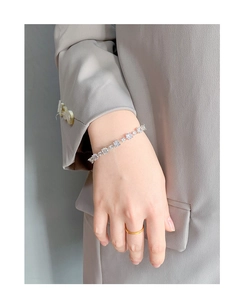 Close-up of sparkling silver bracelet with square and round zircons on model's wrist