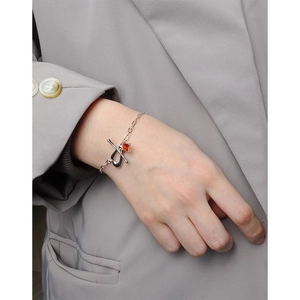 Silver S925 OT buckle bracelet with a square red zircon on a grey suit background