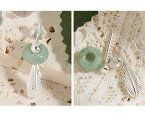 Detail of S925 sterling silver earrings with green jade ring and feather charm