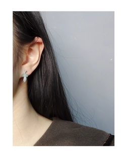 Detailed view of S925 silver leaf earring with a green jade donut bead on the ear