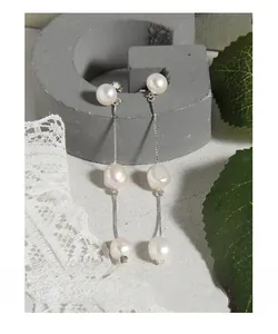 Détail de boucles d'oreilles frangées en argent S925 avec trois perles naturelles
