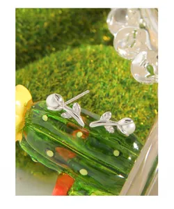 Détails macro de boucles d'oreilles tulipes en argent S925 avec perles délicates