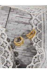 Macro shot of S925 sterling silver stamp on golden minimalist double hoop earrings