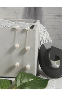 Détail de boucles d'oreilles pendantes en argent S925 avec trois perles d'eau douce