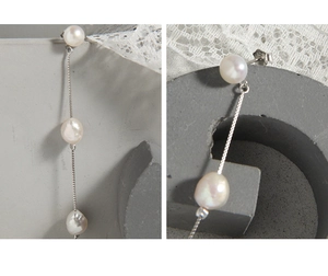 Gros plan sur les boucles d'oreilles en argent S925 avec trois perles naturelles