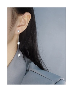 Détail de boucles d'oreilles en argent S925 avec trois perles blanches sur longue chaîne