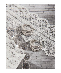 Macro detail of S925 sterling silver double-layered hoop earrings with minimalist design