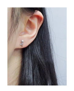 Gros plan de boucles d'oreilles tulipes minimalistes en argent avec perle sur l'oreille