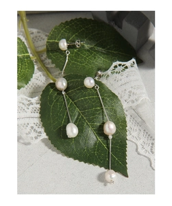 Vue détaillée de boucles d'oreilles longues en perles baroques et chaînes en argent