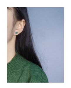 Detail of a minimalist square emerald zircon earring on S925 silver stud