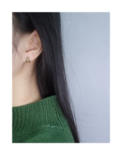 Close-up of minimalist U-shaped gold earrings worn by a model in a side view profile