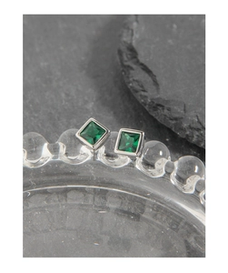 Macro detail of square emerald green zircon earrings set in S925 sterling silver frame