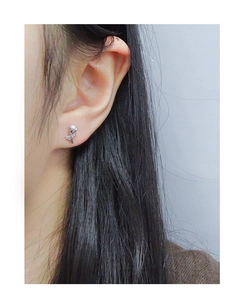 Gros plan d'une boucle d'oreille tulipe en argent S925 montrant le détail floral épuré