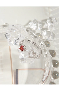 Detail of S925 silver adjustable ring featuring a red zircon and hollow heart design