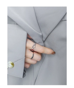 Detail of S925 sterling silver ring set with red heart zircon on grey fabric background