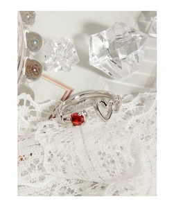 Detail view of S925 silver open ring featuring a hollow heart and a red zircon stone