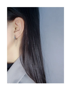 Gros plan de boucles d'oreilles nœud en argent S925 portées pour un style moderne