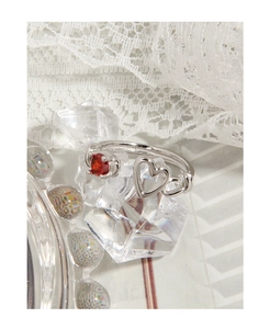 Detail of S925 sterling silver heart ring with sparkling red zircon in a soft lace setting