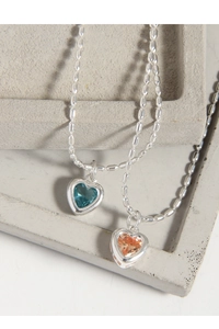 Détail de pendentifs en cristal en forme de cœur bleu et rose avec chaînes à perles