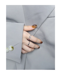 Detail of S925 silver rings set with heart-shaped red zircon on a grey suit background