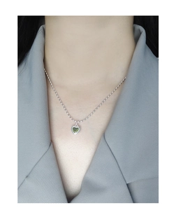 Détail d'un pendentif cœur en zircon vert sur chaîne à perles en argent S925 sur modèle